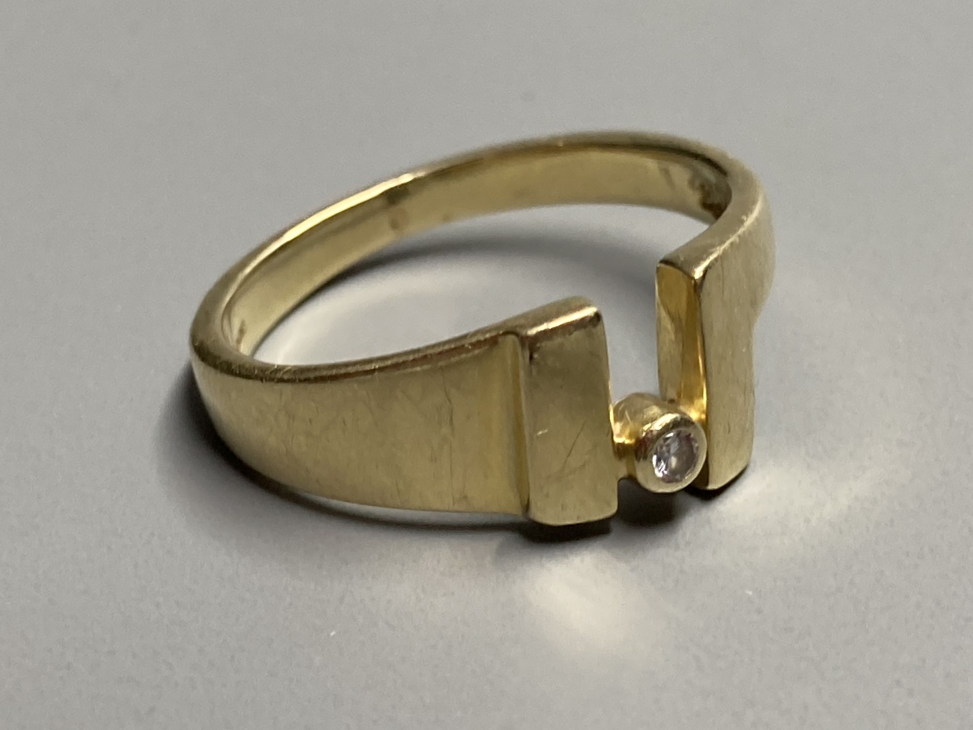 A modernist continental 585 yellow metal and single stone diamond ring, size O/P, gross 4 grams.